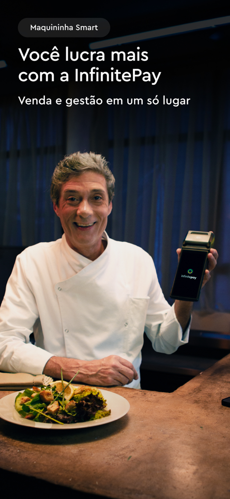Uno chef sorridente che tiene in mano un terminale di carte smart InfinitePay in un ristorante.