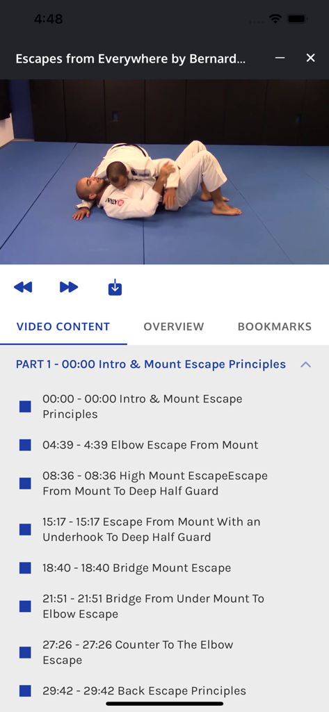Captura de tela da interface do aplicativo BJJ Fanatics mostrando uma lição em vídeo instrucional e lista de capítulos para técnicas de fuga de montada