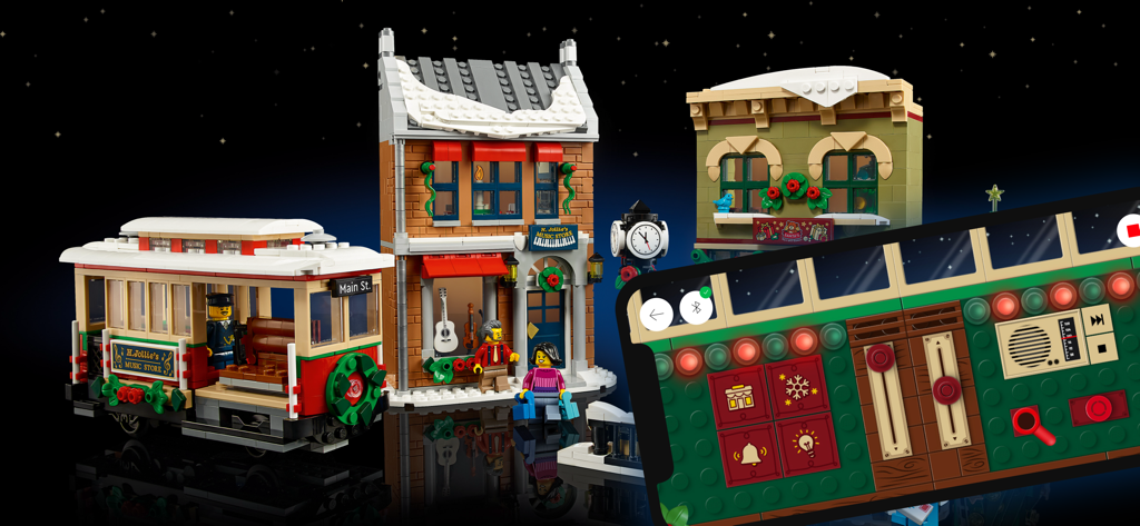 Smartphone showing the LEGO Powered Up control panel next to a LEGO Holiday Main Street tram and buildings