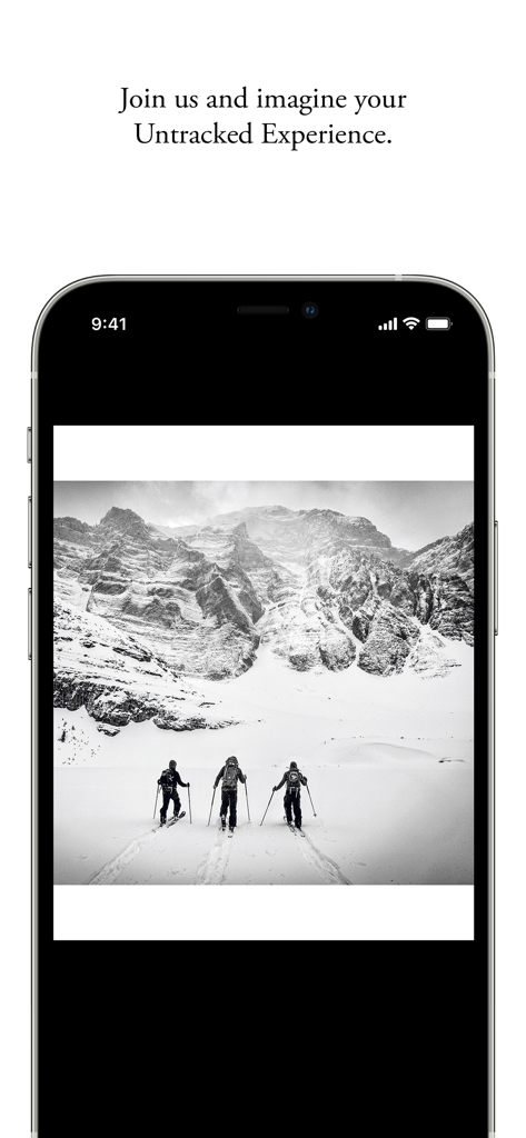 Drei Skifahrer touren durch eine verschneite Bergkette in Schwarz-Weiß-Fotografie