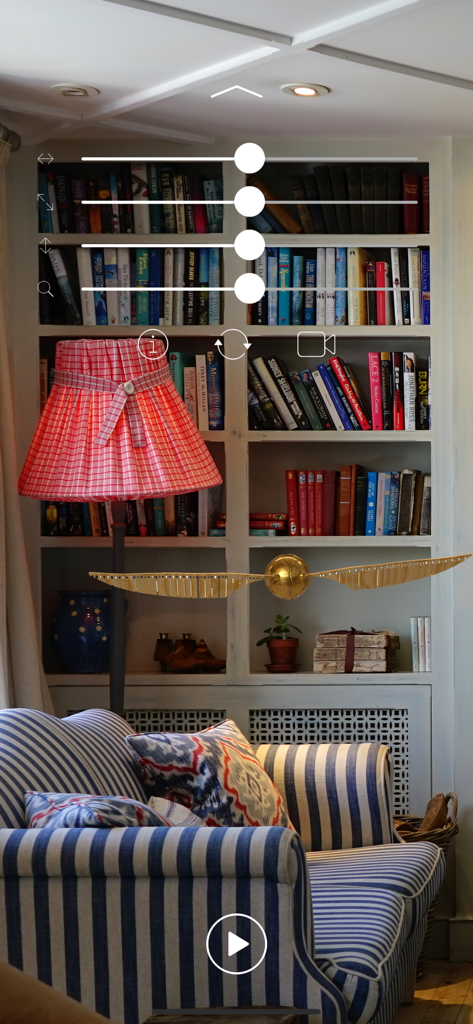 Harry Potter's  Golden Snitch - Augmented reality view of a golden snitch flying in front of a bookshelf with slider controls for size and position.