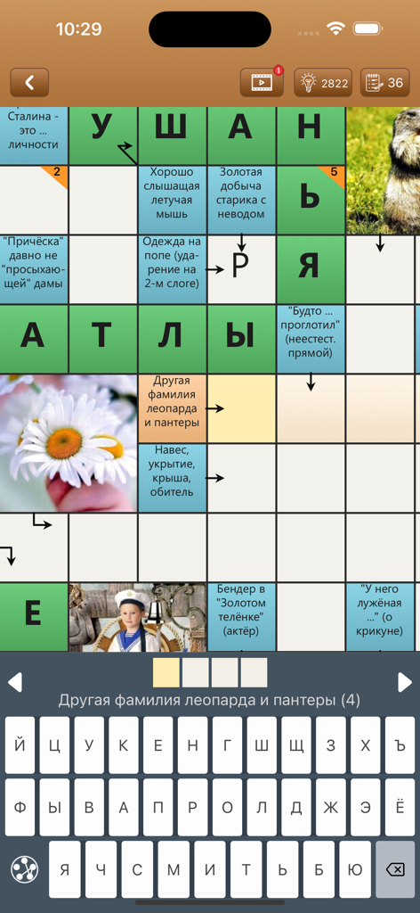 Сканворд Фан - A mobile screenshot showing a Russian scanword puzzle grid with clues and a Cyrillic keyboard