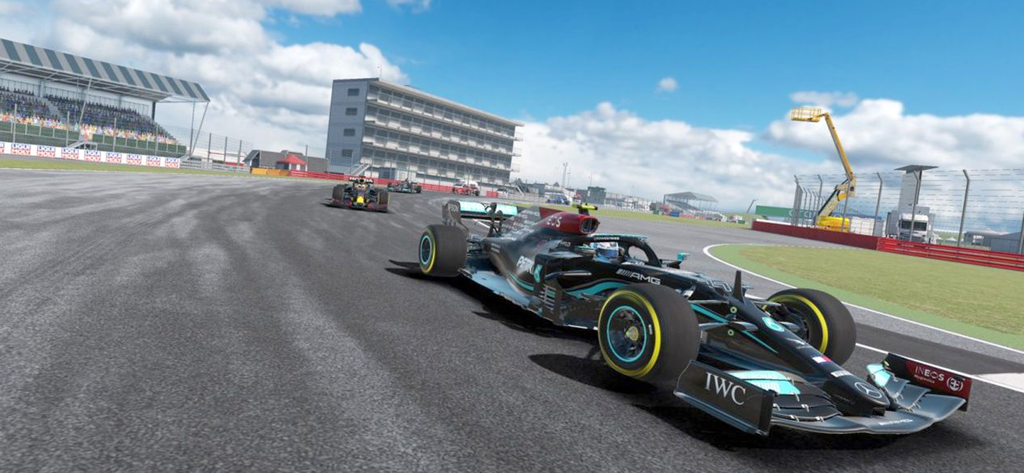 Um carro de corrida Formula dirigindo em uma pista de corrida profissional com arquibancadas ao fundo