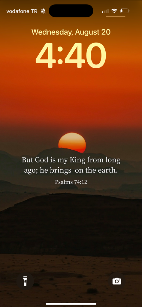 Lockscreen Bible Verse Widget - An iPhone lock screen displaying a Bible verse from Psalms 74:12 over a scenic sunset background.