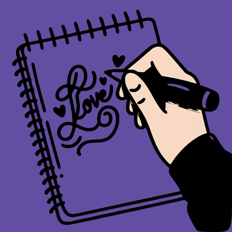a hand writing “love” in calligraphy on a notebook