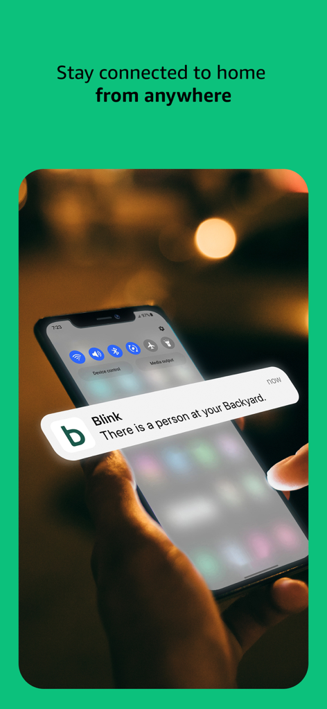 Un smartphone affichant une notification Blink Home Monitor concernant une personne dans l'arrière-cour.