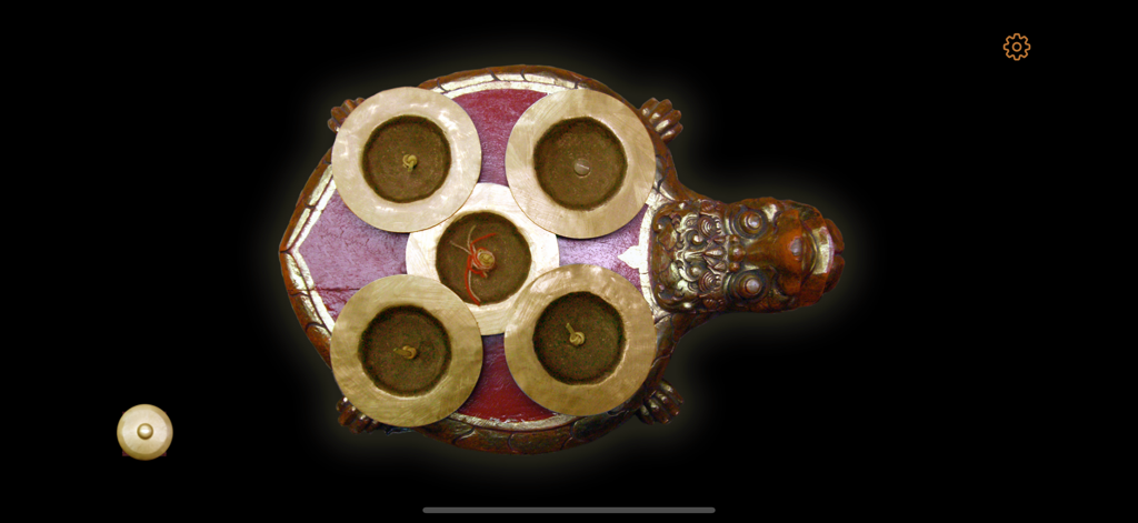 Ketuk Cengceng - Vista cenital de un instrumento de percusión Cengceng balinés tradicional sobre una base en forma de tortuga dentro de la aplicación