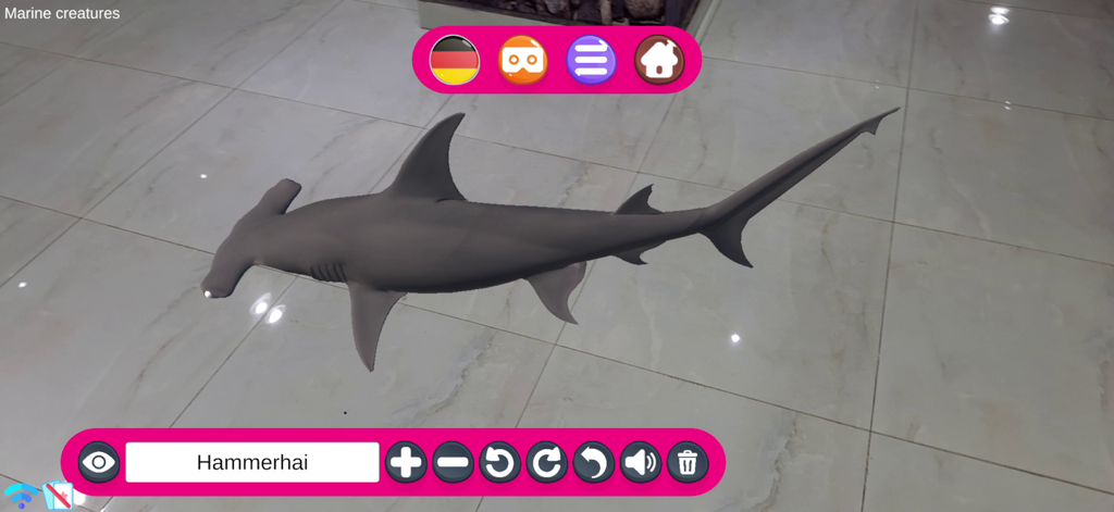 A 3D augmented reality hammerhead shark displayed on a floor through the AR Kids Kit 4D educational app.