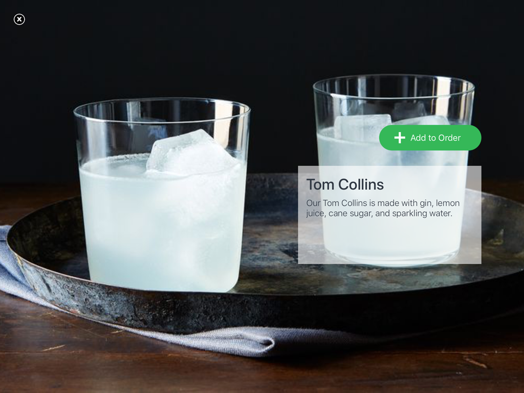 A digital menu screen showing a Tom Collins cocktail with an add to order button