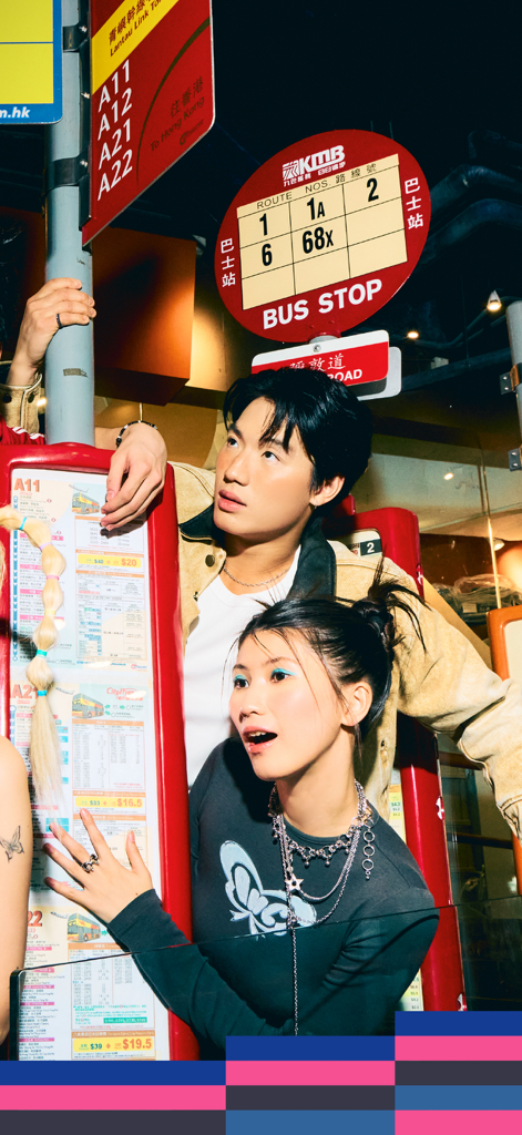 朗豪坊 - Dos jóvenes elegantes posando frente a una exhibición de señal de parada de autobús de Hong Kong