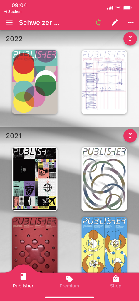 Interface da biblioteca digital do aplicativo PUBLISHER exibindo capas da revista comercial suíça para publicações e impressão, organizadas por ano