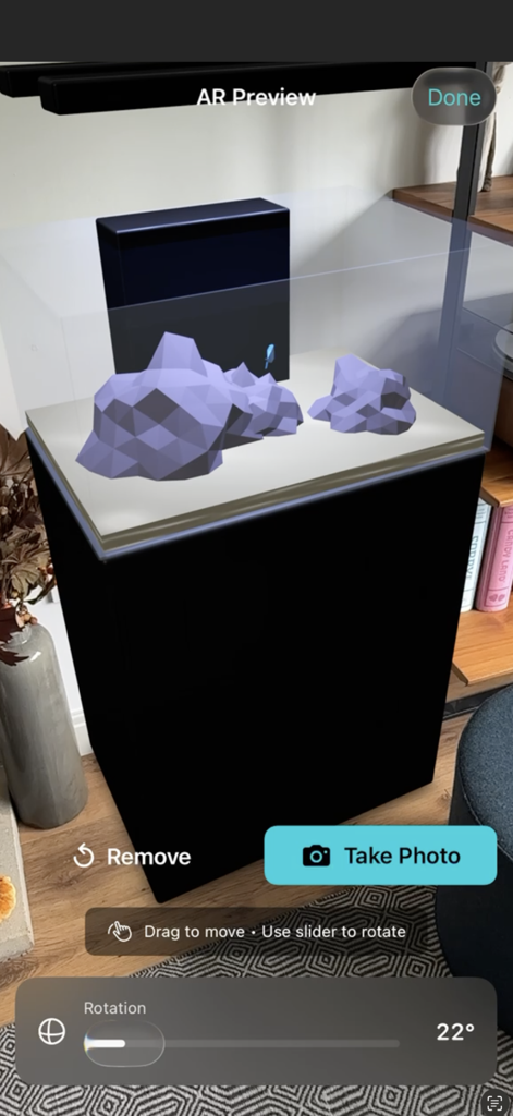 Aquarium Planner AR - Augmented reality preview of a custom aquarium with rockwork and a black stand in a home living room