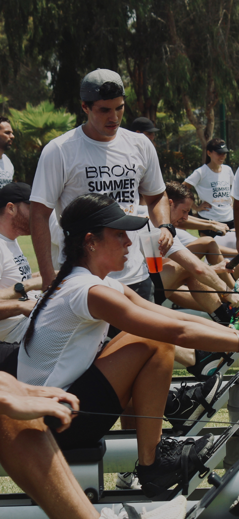 BROX - Un gruppo di persone che gareggiano su vogatori durante un evento di fitness all'aperto chiamato BROX Summer Games.