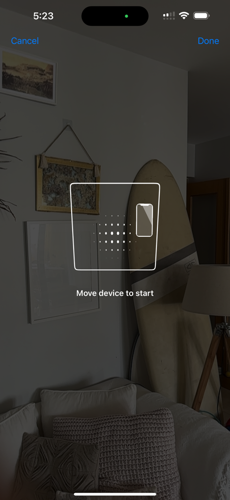 AI Room Plan Scanner app interface showing a prompt to move the device to start scanning a living room with a surfboard and pictures.