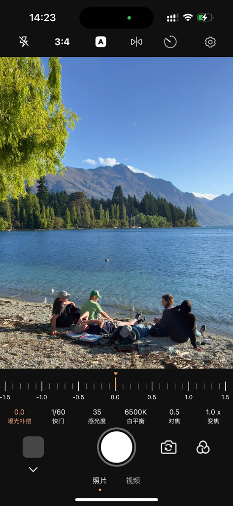 ProCam professional camera app interface showing manual controls over a landscape view of a lake and mountains