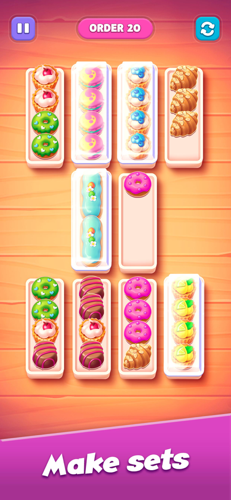 A mobile game screen showing colorful pastries being sorted into boxes to make matching sets.