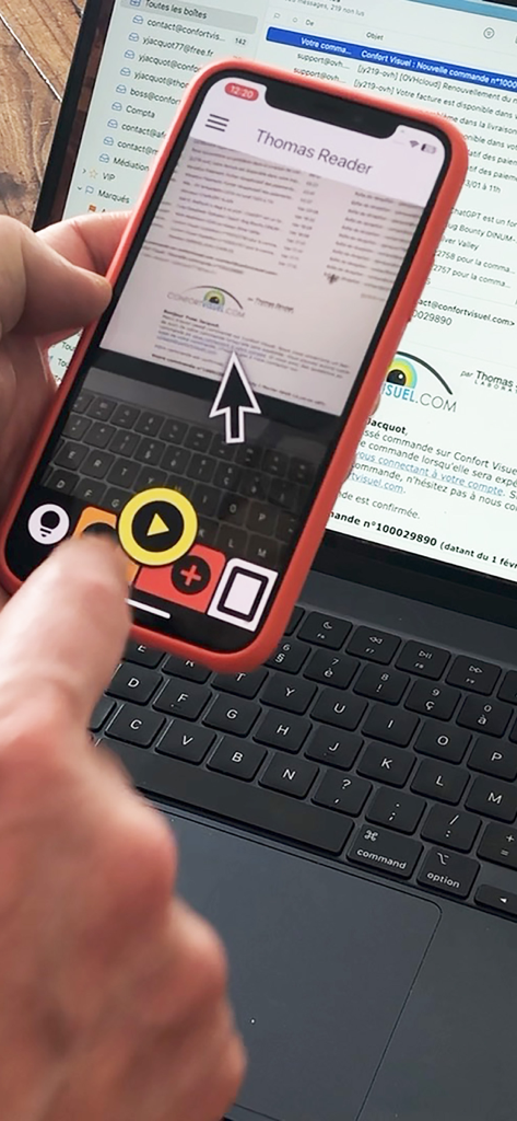 Thomas Reader - A person using the Thomas Reader app on an iPhone to scan and read text from a laptop screen