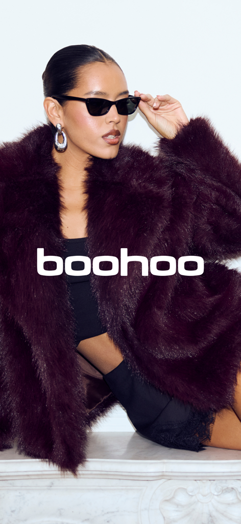 A woman in a trendy dark burgundy faux fur coat and sunglasses with the boohoo logo