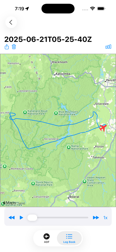 Una schermata di un'app mobile che mostra un percorso di volo blu e un'icona di aereo rossa su una mappa topografica verde del Blue Mountains National Park.