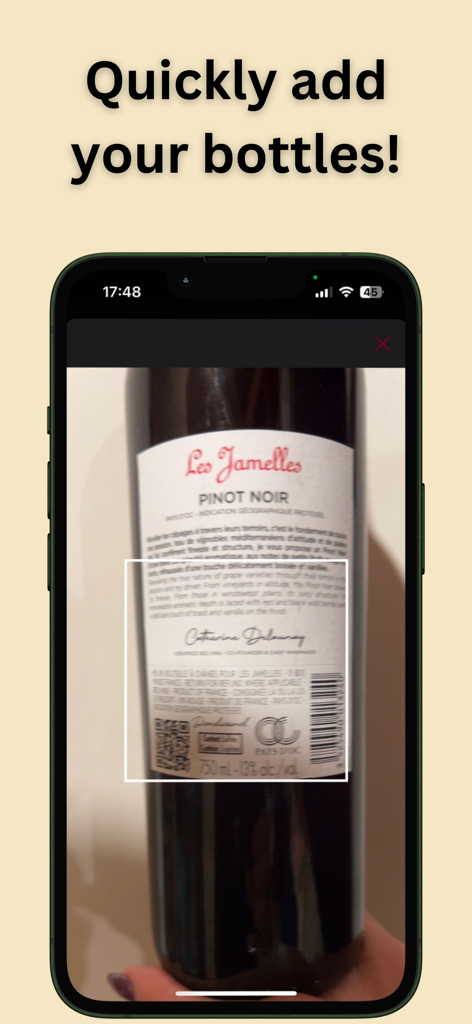 A smartphone scanning a bottle of Pinot Noir to add it to the wine cellar inventory.