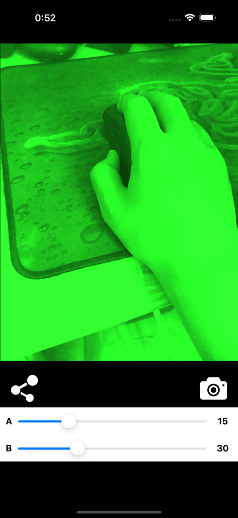 A screenshot showing a green night vision filter applied to a hand on a mouse with UI adjustment sliders