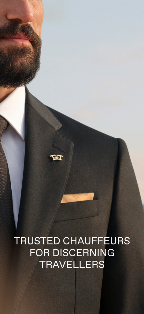 A professional chauffeur in a black suit with a Wheely logo pin.
