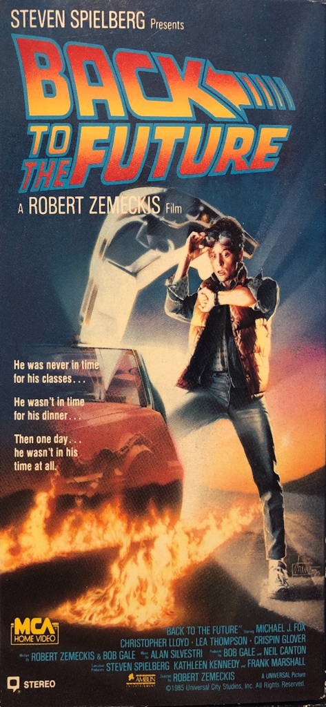 Movie Collector - Portada VHS de la película Regreso al Futuro con Marty McFly de pie junto al DeLorean volador con huellas de neumáticos en llamas.