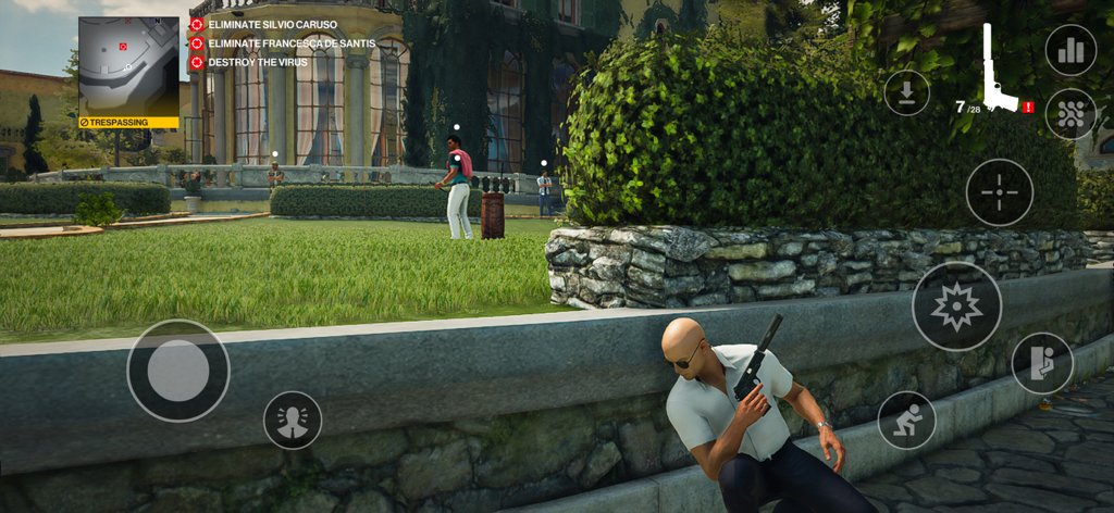 Agent 47 sneaking behind a stone wall during a mission in Hitman World of Assassination mobile game.