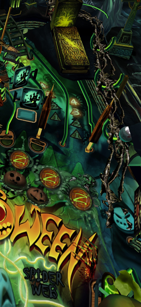 Captura de tela da jogabilidade do jogo de fliperama Halloween Pinball, mostrando uma mesa com tema assustador com luzes verdes e uma lápide.