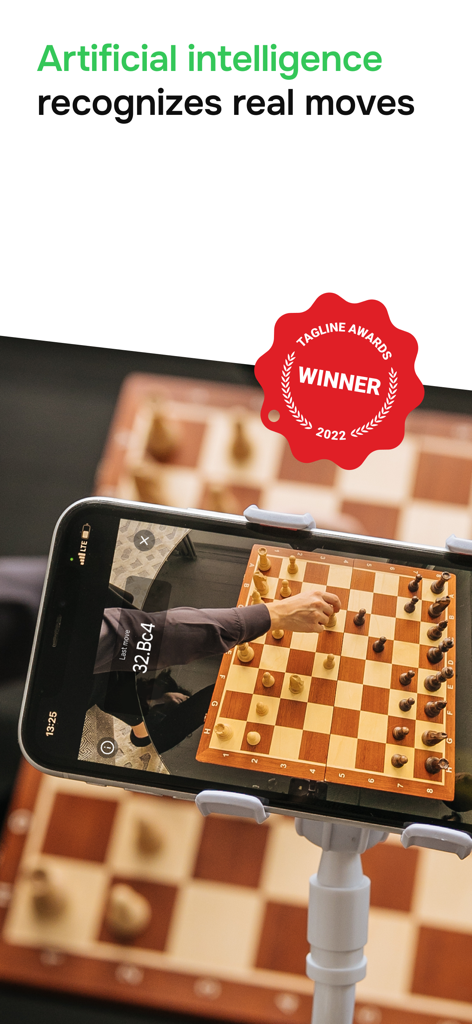 A smartphone on a tripod using the idChess app to recognize moves on a physical chessboard