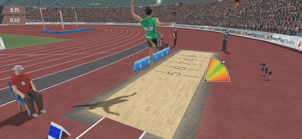 An athlete performing a long jump into a sandpit during a track and field competition in a stadium.
