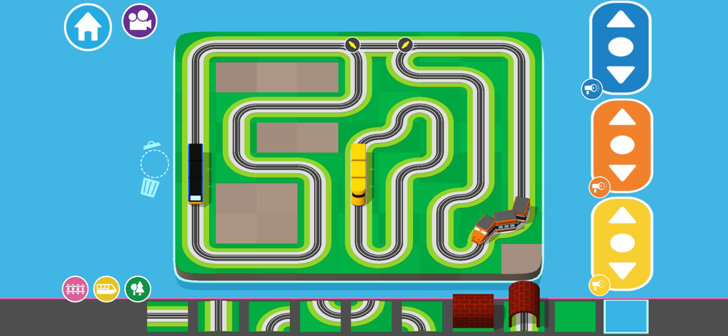 A top-down view of a colorful train track layout being built in the Train Kit app with different trains and scenery pieces.