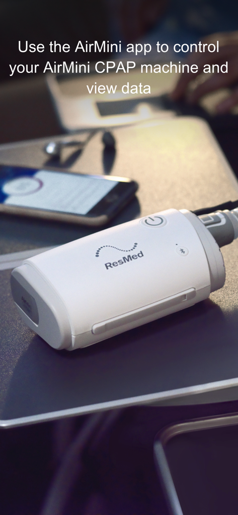 ResMed AirMini travel CPAP device next to a smartphone running the control app