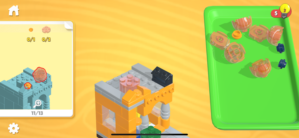 Buildit - Chill Brick Game - Digital brick building interface showing a blueprint guide and a tray of orange and blue pieces for constructing a model