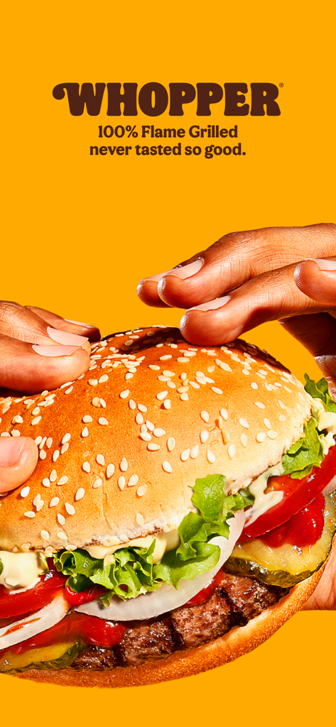 Close-up of hands holding a Burger King Whopper burger on a yellow background with flame grilled text