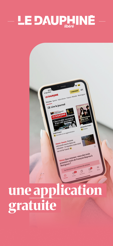 Le Dauphiné Libéré, actualités - A hand holding a smartphone displaying the Le Dauphine Libéré news app interface on a pink background