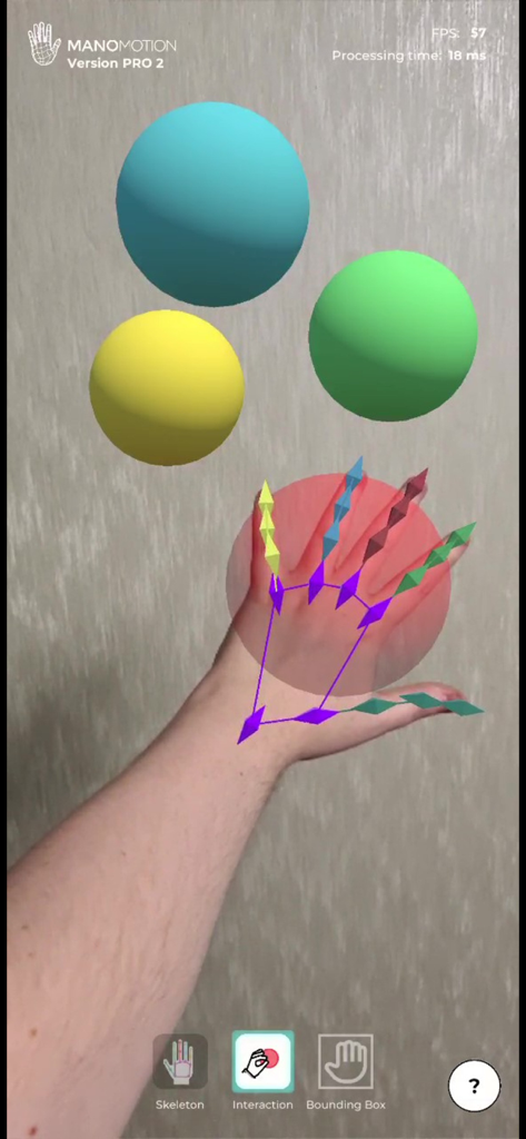 ManoMotion Tech Pro - A hand with a 21-joint skeleton overlay interacting with virtual 3D spheres in the ManoMotion Tech Pro app.
