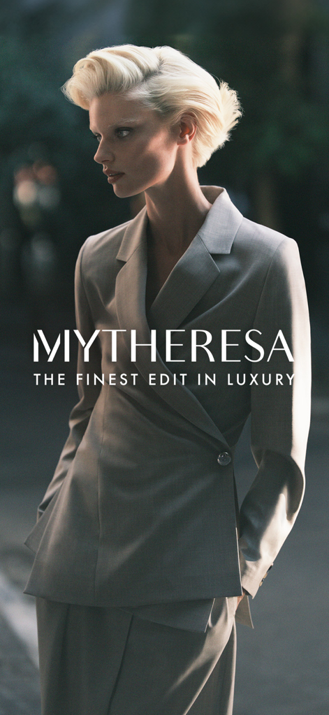 Mytheresa 로고와 슬로건이 있는 테일러드 회색 정장을 입은 여성