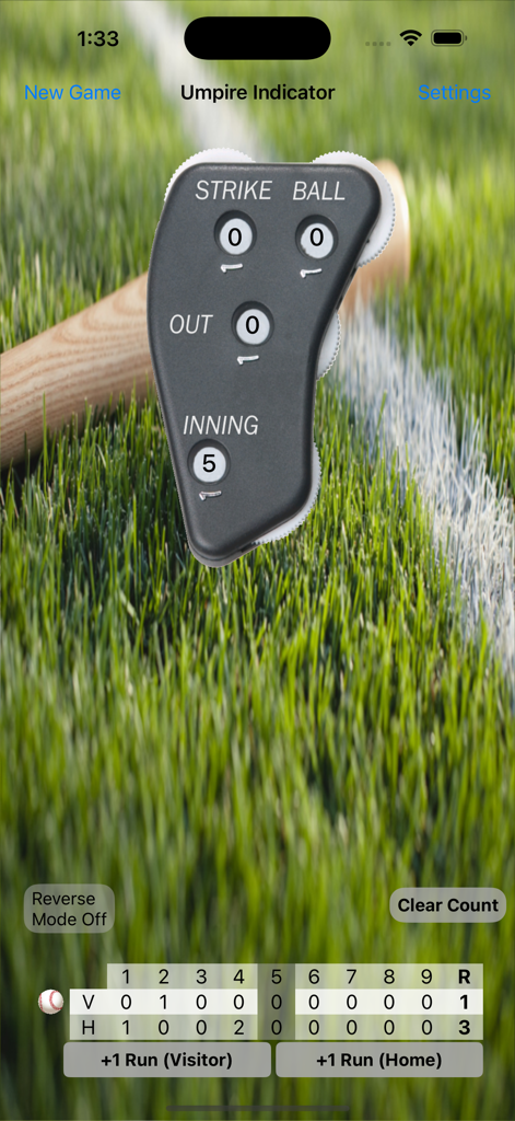 Umpire Indicator Pro digital clicker interface tracking strikes balls outs and scoreboard over a grass field