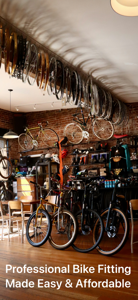 Interior de una tienda de bicicletas profesional con ruedas colgadas del techo y varias bicicletas
