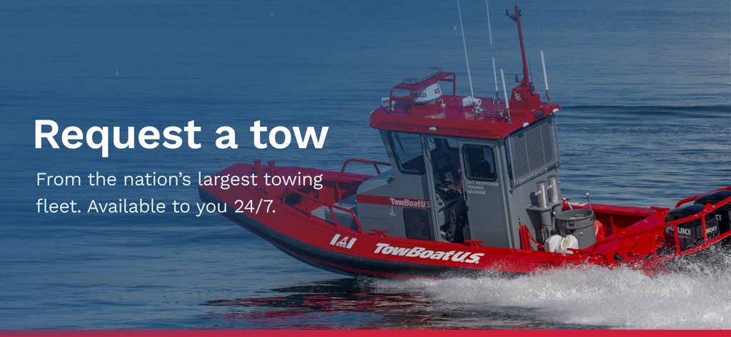 A red TowBoatUS assistance boat on the water promoting 24/7 towing services
