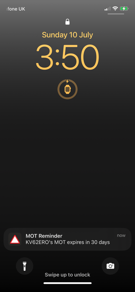 An iPhone lock screen showing an MOT expiry notification for a vehicle registered in the UK