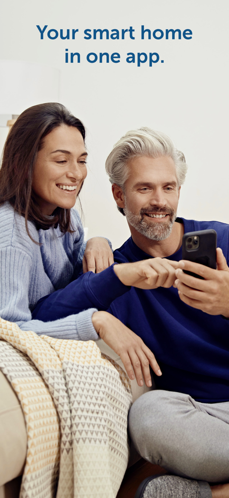 Um casal feliz usando o aplicativo Homematic IP em seu smartphone para gerenciar seus dispositivos domésticos inteligentes