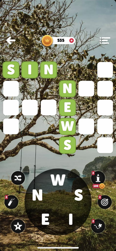 Words of the World! - Crossword puzzle gameplay with a scenic coastal background