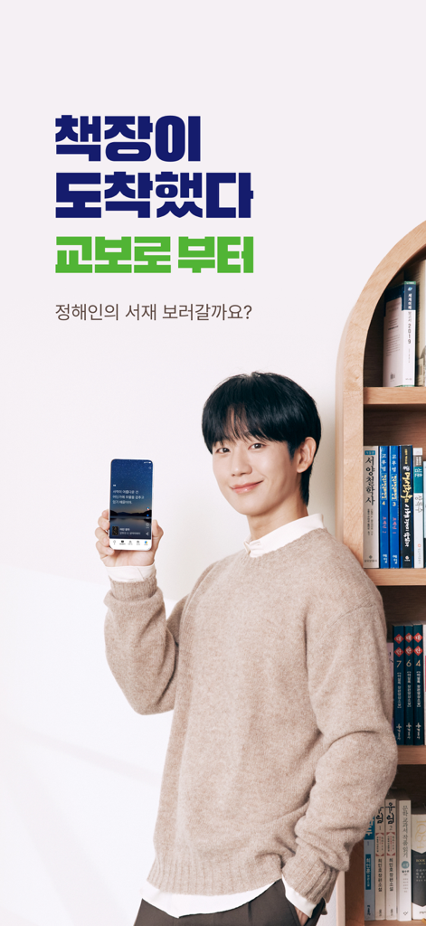 교보생명 - 오늘도 교보로부터 - A smiling man holding a smartphone featuring the Kyobo app next to a wooden bookshelf