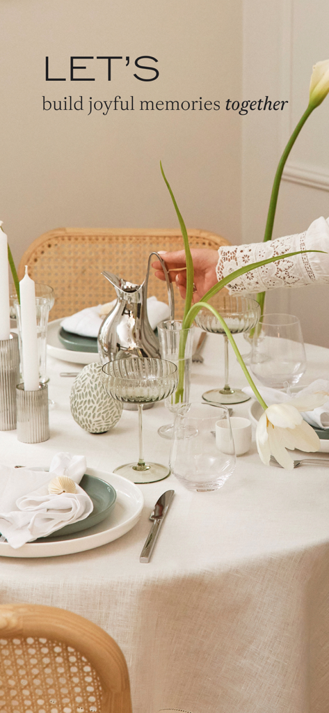 Westwing: Live Beautiful - Mesa de comedor bellamente puesta con lino blanco y accesorios plateados.