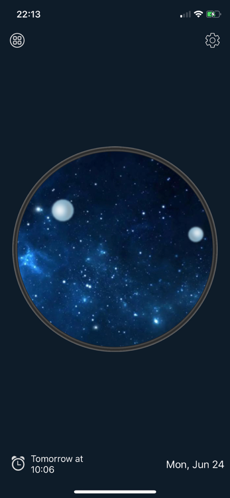 Una esfera de reloj analógica redonda con un fondo temático de galaxia azul y estrellas en la pantalla de un dispositivo móvil