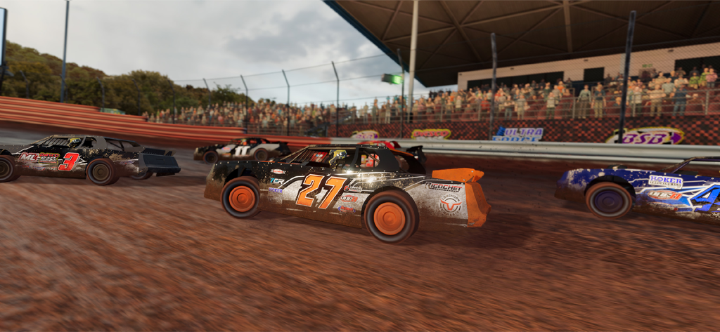 Dirt Trackin 3 - Several stock cars racing on a dirt track oval with a crowded grandstand in the background.