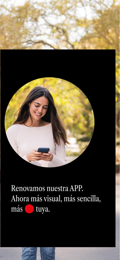 Woman smiling while using the Cajasur banking app on her smartphone outdoors