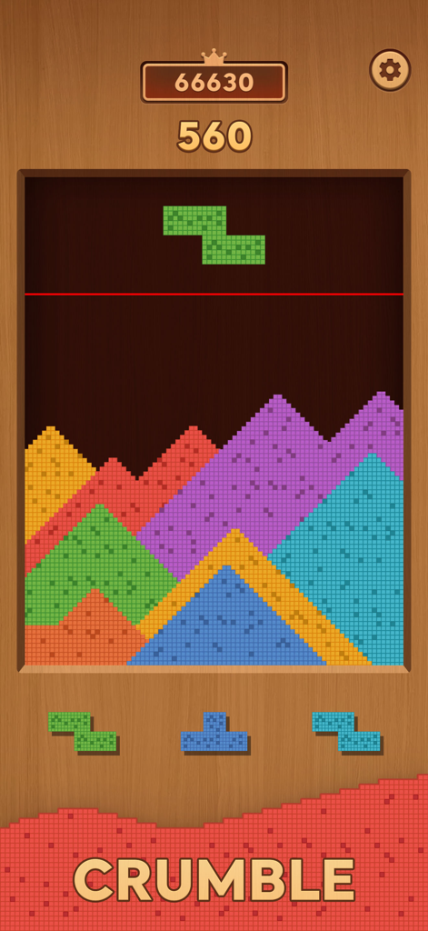 Gameplay of Sand Crush where colorful blocks dissolve into piles of sand on a wooden background.